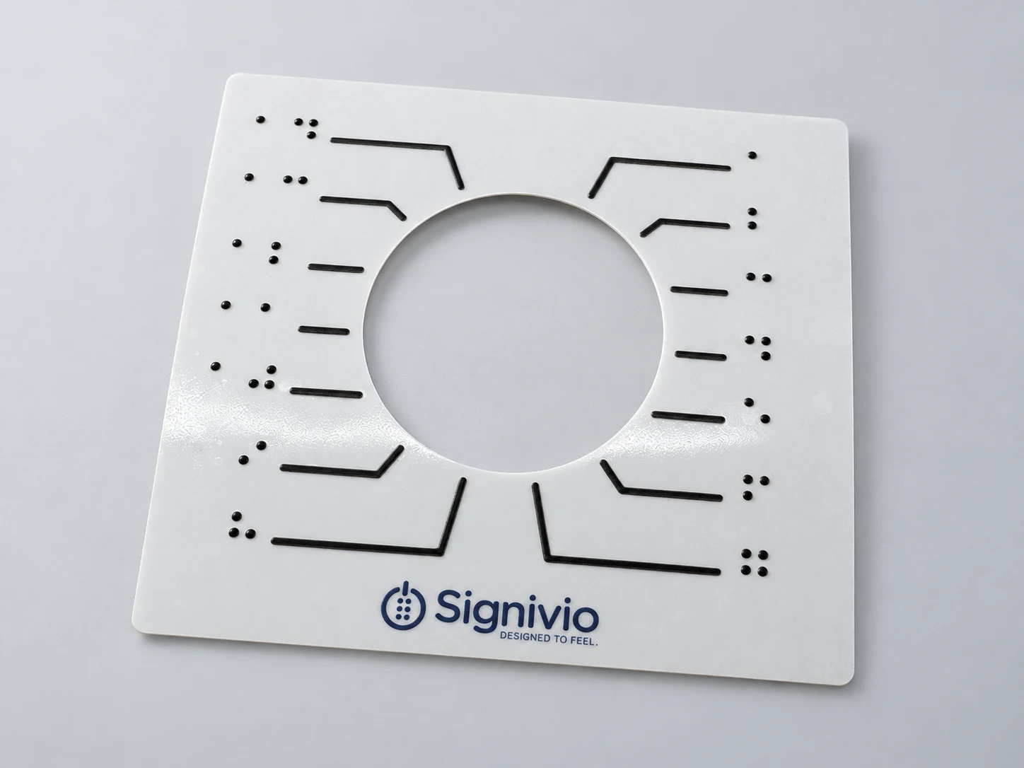 Produktvisualisierung eines Signivio-Aufklebers: runde Aussparung für den Drehknopf, erhabene Führungslinien und Braille-Ziffern.